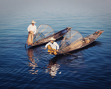 渔夫缅甸旅游景点传统的缅甸渔民缅甸的inle湖捕鱼网,以其独特的单腿划船风格而闻名复古过滤复古效果时尚风格的形象缅甸in背景