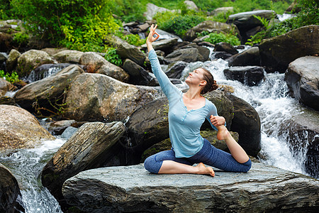 轻运动健康的女人瑜伽阿莎娜EkaPadaRajakapotasana条腿的国王鸽子姿势热带瀑布印度希马查尔邦女图片