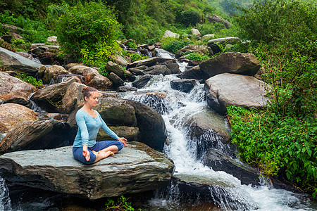 热带瀑布的户外哈他瑜伽的女人帕德马萨纳户外的女人图片