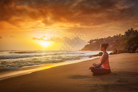 轻运动健康的女人瑜伽冥想放松帕德马萨纳莲花姿势与下巴泥德拉户外热带海滩日落轻的运动健康的女人海滩上瑜伽图片