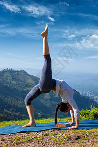 瑜伽户外运动妇女瑜伽阿莎娜,又名帕达乌尔德瓦达努拉纳向上弓姿势背部弯曲户外喜马拉雅山上午女人户外瑜伽图片