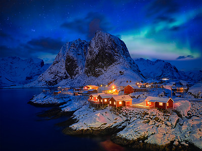 著名的旅游景点汉诺伊渔村洛福腾岛上,挪威红色的罗布屋,冬天的雪晚上用北极光照亮挪威洛福滕岛的汉诺伊渔村图片