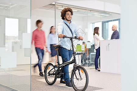 轻的商人与自行车同行,而同事办公室背景图片