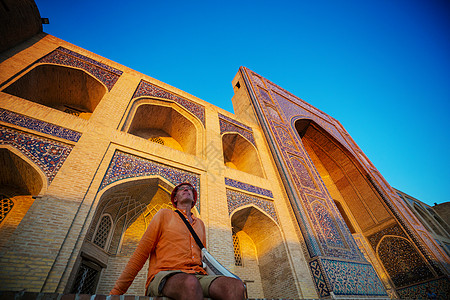 乌兹别克斯坦古代历史建筑附近的游客高清图片