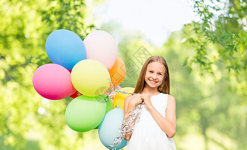 小丑气球庆祝,儿童生日聚会的快乐的女孩与彩色气球绿色的自然背景快乐的女孩自然背景上气球背景