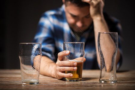 酒精中,酒精成瘾人们的男酒精饮料啤酒璃晚上晚上用璃杯喝啤酒图片