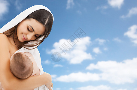 家庭,母乳喂养母亲的快乐的轻母亲与小婴儿吸吮乳房的天空背景母亲母乳喂养婴儿天空背景图片