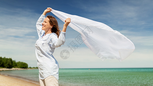 人与休闲的快乐的女人与披肩风中挥动夏季海滩快乐的女人,披肩海滩上迎风飘扬图片