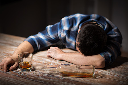 酒精成瘾人的男酒精与杯威士忌瓶子躺桌子上晚上睡觉晚上桌子上喝了杯酒的醉汉图片