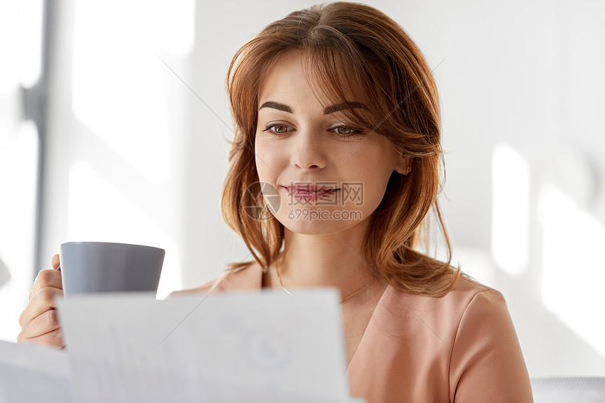 商业人的工作办公室文件喝咖啡的女商人女商人着报纸办公室喝咖啡图片