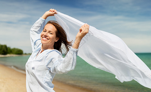 人与休闲的快乐的女人与披肩风中挥动夏季海滩快乐的女人,披肩海滩上迎风飘扬图片