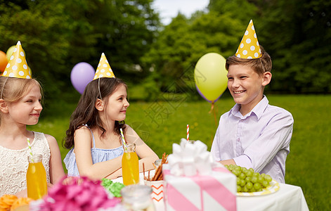 假期,童庆祝快乐的孩子坐桌子上的生日聚会夏季花园快乐的孩子夏季花园的生日聚会上图片