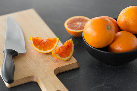 食物,水果健康饮食血橙菜刀木制切割板切割板上的橘子刀背景图片