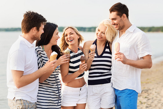 友谊休闲人的群穿着条纹衣服的快乐朋友海滩上吃冰淇淋快乐的朋友海滩上吃冰淇淋图片
