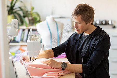 人,服装裁缝的时装师与缝纫机布制作新的服装工作室时尚师与缝纫机工作背景图片