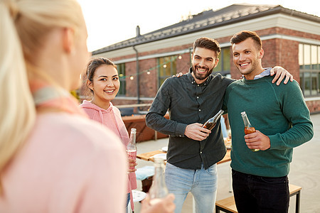 休闲人们的快乐的朋友与饮料拥抱屋顶聚会快乐的朋友屋顶聚会上喝酒拥抱图片