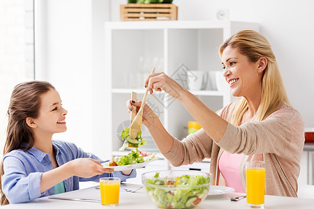 健康饮食,家庭人的快乐的母亲女儿家里厨房吃蔬菜沙拉快乐的家庭家里厨房吃沙拉图片