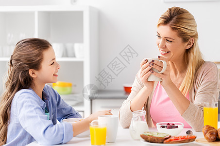 食物,健康饮食,家庭人的快乐的母亲女儿家里的厨房吃早餐快乐的母亲女儿家吃早餐图片