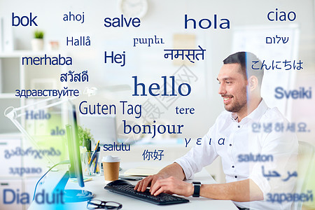 翻译商业技术微笑的男翻译商人办公室的电脑键盘上打字,用同的外语问候语计算机的人胜过外语的单词背景图片