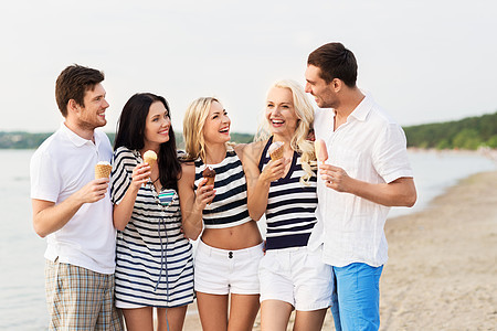 友谊休闲人的群穿着条纹衣服的快乐朋友海滩上吃冰淇淋快乐的朋友海滩上吃冰淇淋图片