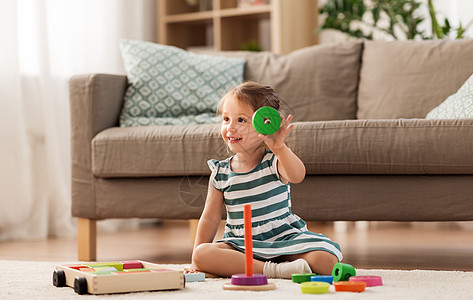 童人的快乐的三岁女婴玩玩具块家快乐的女婴家里玩玩具积木图片