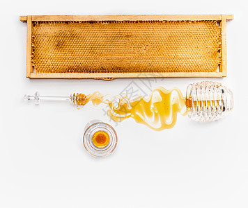 蜂窝木制框架与蜂蜜罐子倒白色背景上的勺子,顶部视图健康的食物图片