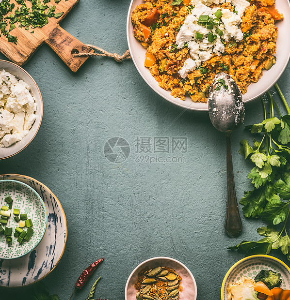 食物背景框架与健康素食蒸粗麦粉锅碗与配料蔬菜,草药fta奶酪黑暗的桌子上,顶部视图,平躺,框架图片