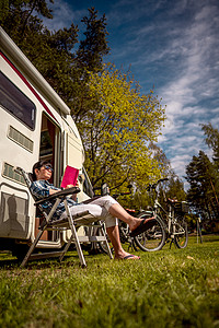 女人放松下来,野营附近读本书房车度假家庭度假旅行,汽车之家度假旅行图片