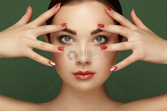 美丽的黑发女人,化妆完美迷人的女孩红色的嘴唇指甲完美的眉毛护肤基金会美丽的女孩绿色背景的孤立时尚照图片