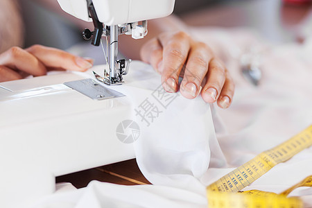 裁缝工作室密切妇女裁缝的手与缝纫机工作背景图片