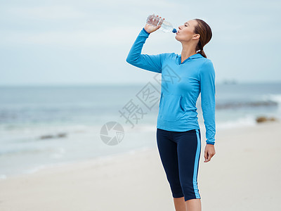 运动的轻女人海边喝水图片