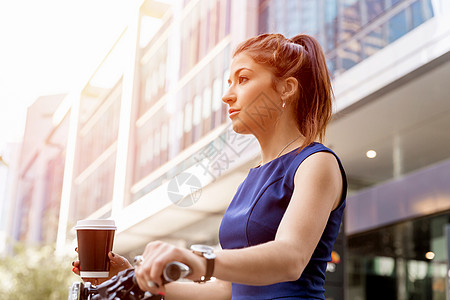 喝咖啡场景轻的女人骑自行车上下商务青妇女骑自行车喝杯咖啡背景