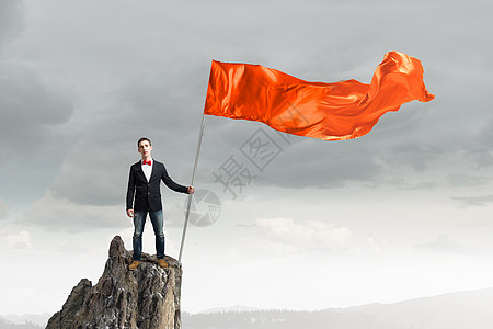橙色挥舞的人学生家伙穿着休闲,手里着旗子背景图片