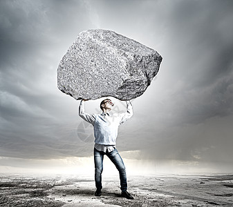 搬石头的家伙轻强壮的男人头顶着巨大的石头图片