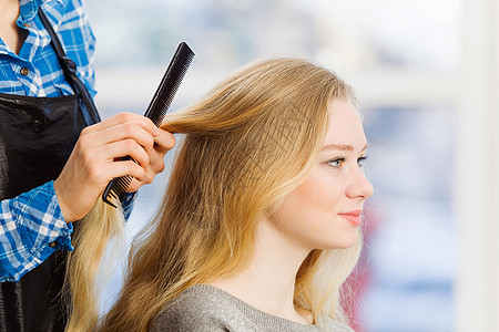 美容院理发师理发师椅子上的轻女人图片