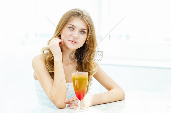 轻漂亮的女人坐咖啡馆里喝着杯饮料图片