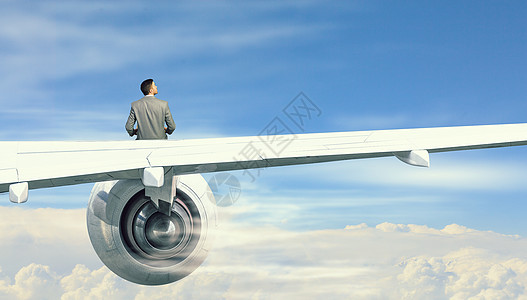 飞行飞机的机翼上轻的商人坐飞机上看书图片
