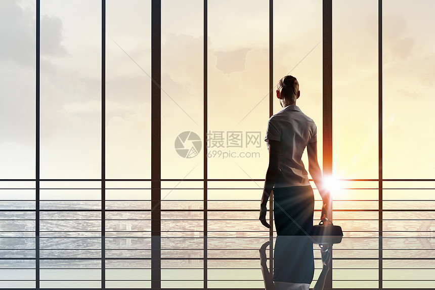 下个成功的日子女商人办公室窗户上看日出的后景