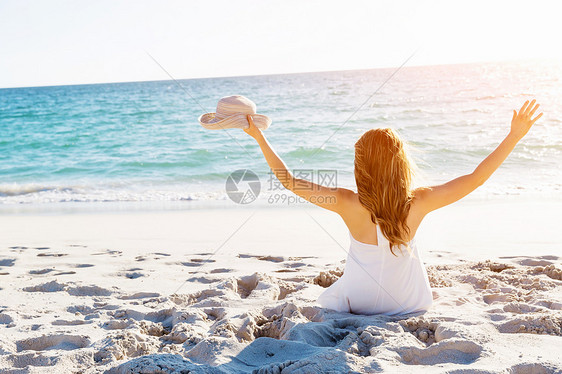 轻的女人坐海滩上坐沙滩上的轻漂亮女人的肖像图片