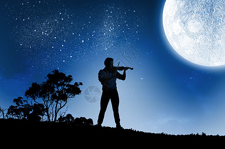 男小提琴手晚上拉小提琴的人的剪影图片