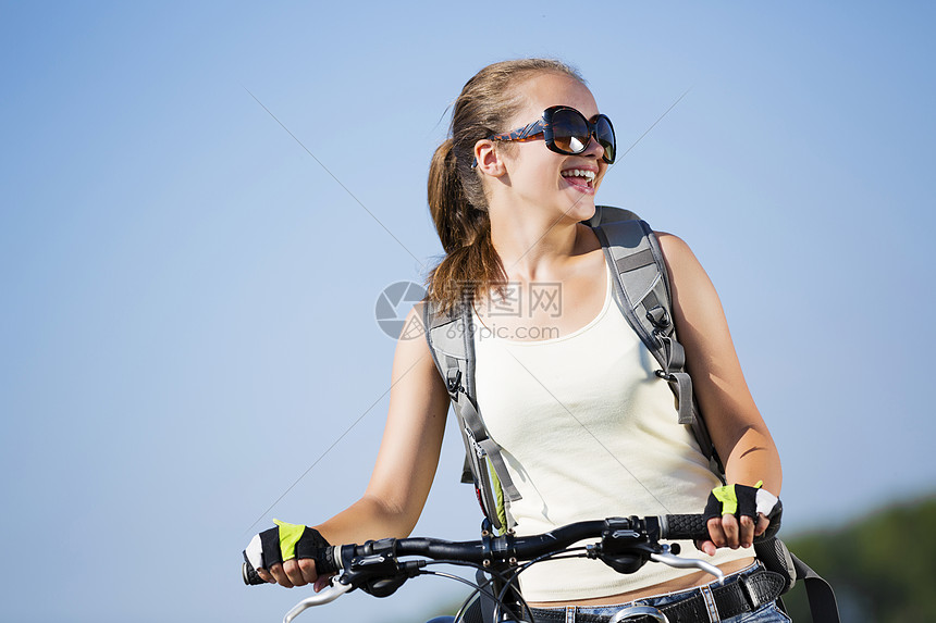 轻漂亮的女人公园里骑自行车夏季自行车步行图片