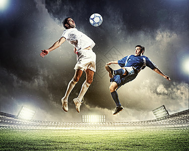 两名足球运动员击球两名足球运动员体育场跳以击球图片