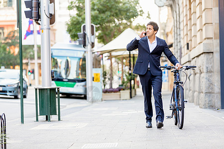 男袜成功的商人骑自行车成功的商人穿着西装骑自行车着手机背景