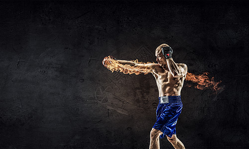 拥力量耐力戴手套的强壮拳击手靠水泥墙上图片