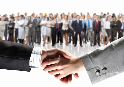 商务握手与背景上的人群握手的特写图片
