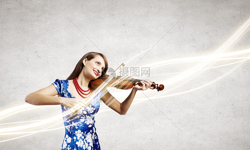 女小提琴手轻迷人的女人穿着蓝色连衣裙拉小提琴