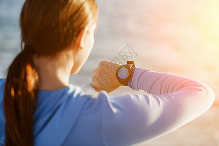跑步的女人带着心率监视器海滩上跑步轻的跑步女子,心率监测器海滩上跑步图片