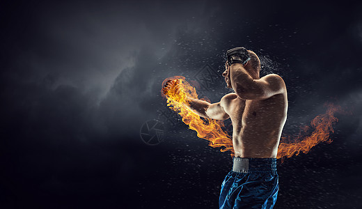 火焰拳头背景箱式战斗机户外训练黑暗背景下的强壮拳击手展示了力量耐力背景