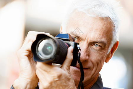 城市里带着相机的老男寻找好的拍摄角度背景