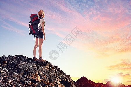 轻的女人登山者站山顶上的漂亮山顶上图片